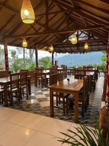 a restaurant with wooden tables and chairs and lights at The Garuda Villa and Restaurant in Bedugul