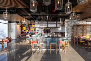 a restaurant with colorful chairs and a bar at Wink Danang Centre, Unscripted by Hyatt - 24 Hours stay in Danang