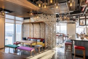 a restaurant with colorful chairs and tables and windows at Wink Danang Centre, Unscripted by Hyatt - 24 Hours stay in Danang +38 photos
