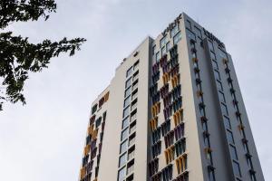 a tall white building with many windows at Wink Danang Centre, Unscripted by Hyatt - 24 Hours stay in Danang