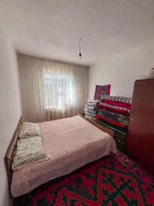 a small bedroom with a bed and a window at Begimay Inn in Toguz-Bulak