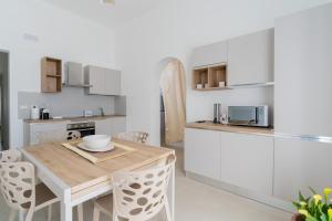 a kitchen and dining room with a wooden table and chairs at Al Calico in Galatone