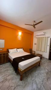 a bedroom with a large bed with an orange wall at Gravity Groups Core - Sivadurai Residency in Puducherry Airpoert
