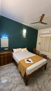 a bedroom with a bed and a green wall at Gravity Groups Core - Sivadurai Residency in Puducherry Airpoert +4 photos