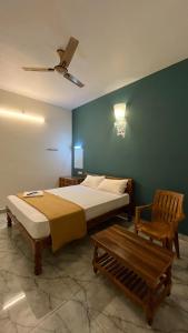 a bedroom with a bed and a bench in it at Gravity Groups Core - Sivadurai Residency in Puducherry Airpoert