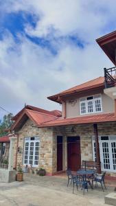 a house with a table and chairs in front of it at Villa Lunka in Nuwara Eliya