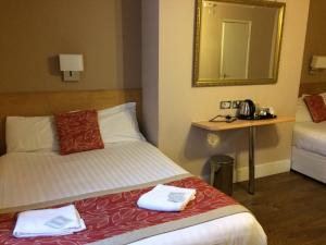 Habitación de hotel con cama y espejo en The Grapevine Hotel en Londres