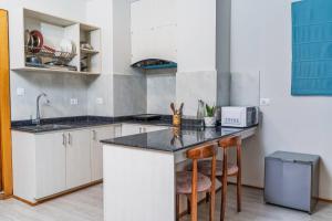 a kitchen with white cabinets and a counter with stools at Marlo Hotels in Kathmandu