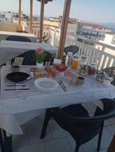 a white table with food on it on a balcony at Achilleion-Edipsos in Loutra Edipsou