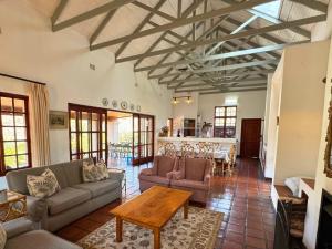 a living room with couches and a table at Ntsinini Trout & Leisure Farm in Waterval Boven
