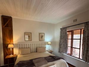 a bedroom with a large bed and a window at Ntsinini Trout & Leisure Farm in Waterval Boven +114 photos
