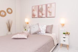 a white bedroom with a bed and a picture on the wall at La Casa Seni Near Athens Airport in Papangeláki