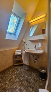 a bathroom with a sink and a skylight at Landhotel Ölmühle in Mömbris +74 photos
