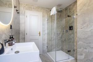 a bathroom with a shower and a sink and a shower at Villa Patriot Boutique Hotel in Mariánské Lázně