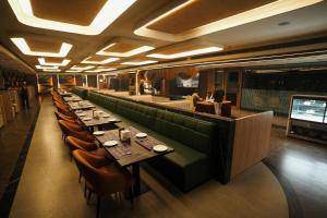 a dining room with long tables and a bar at Hotel Shubham Celebrations-Miyapur in Lingampalli