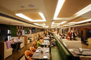 a restaurant with people sitting at long tables at Hotel Shubham Celebrations-Miyapur in Lingampalli +27 photos