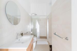 a white bathroom with a sink and a mirror at Al Calico in Galatone +65 photos