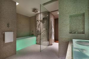 a bathroom with a glass shower and a tub at Andaz Xintiandi, Shanghai, By Hyatt in Shanghai