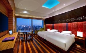 a bedroom with two beds and a table with a view at Andaz Xintiandi, Shanghai, By Hyatt in Shanghai