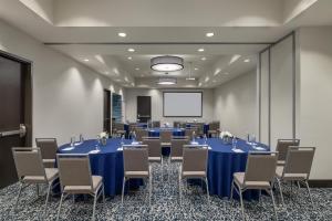 a conference room with tables and chairs and a screen at Hampton Inn & Suites - Roanoke-Downtown, VA in Roanoke