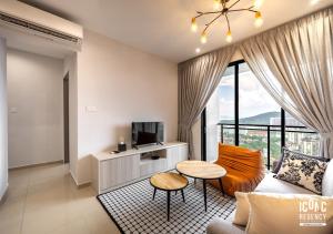 a living room with a couch and a tv at Iconic Regency Service Residences, managed by Iconic Hotel in Bayan Lepas