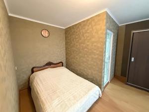 a bedroom with a bed and a clock on the wall at Grand hotel dmanisi in Dmanisi
