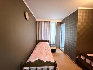 a bedroom with a bed and a clock on the wall at Grand hotel dmanisi in Dmanisi