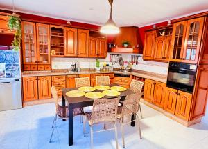 a kitchen with wooden cabinets and a table with chairs at myplace in Tiagua +28 photos