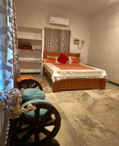 a bedroom with a bed and a chair in it at AUM VILLA Homestay in Pondicherry and Auroville in Puducherry Airpoert
