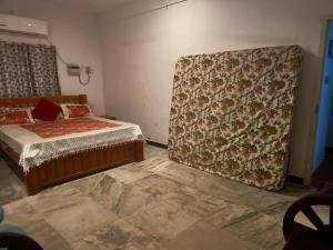 a bedroom with a bed and a flowered wall at AUM VILLA Homestay in Pondicherry and Auroville in Puducherry Airpoert