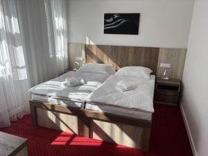 a bedroom with a bed with two towels on it at Penzion Hněvotín 88 in Hněvotín