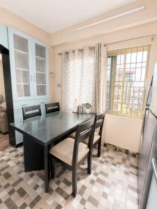 a dining room with a glass table and chairs at Nirva Chey in Kathmandu +4 photos
