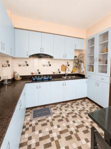a kitchen with white cabinets and a checkered floor at Nirva Chey in Kathmandu