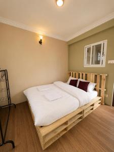 a bedroom with a large bed with white sheets at Nirva Chey in Kathmandu