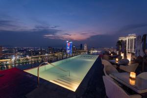 a swimming pool on top of a building at night at Wink Danang Riverside, Unscripted by Hyatt - 24 Hours stay in Danang