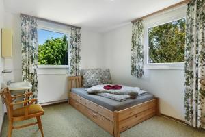 a bedroom with a bed and two windows at Ferienhaus Leni in Edertal
