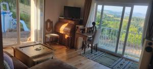 a living room with a tv and a large window at Maison dans le Beaujolais vert in Thizy-les-Bourgs