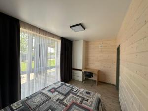 a bedroom with a bed and a desk and a window at Relax Lux in Mykolaivka