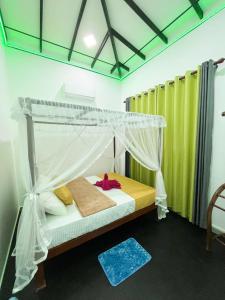 a bedroom with a bed with a canopy at Bule Bells Villa in Matara