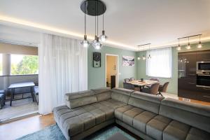 a living room with a couch and a table at Sunshine Homes Zamárdi in Zamárdi