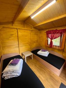 a bedroom with two beds in a wooden cabin at Biržai camping in Biržai +45 photos