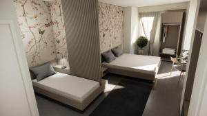 a small room with two beds and a table at Adua Rooms - Tropea Center in Tropea