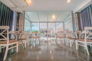 a room with chairs and tables and windows at BCP Hotel in Ban Chang