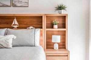 a bedroom with a bed with a wooden headboard at 5-41 Park Street in Evans Head