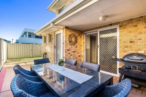 a patio with a table and chairs and a grill at 5-41 Park Street in Evans Head