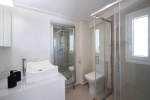 a bathroom with a sink and a shower and a toilet at Virea VA Complex in Vaia +23 photos