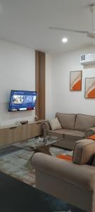 a living room with a couch and a flat screen tv at Nyali luxe 1 bedroom in Nyali