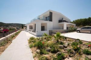 a white house with a garden in front of it at Virea VA Complex in Vaia