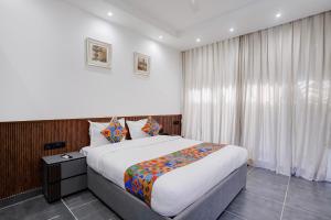 a bedroom with a large bed and a window at FabHotel JM Residency in Mandrem