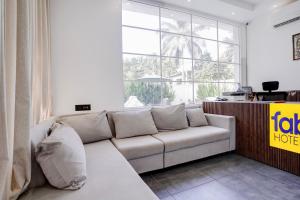 a living room with a couch and a large window at FabHotel JM Residency in Mandrem